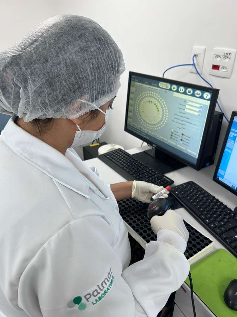 Profissional do Laboratório Palmar realizando análise de uma amostra em equipamento informatizado